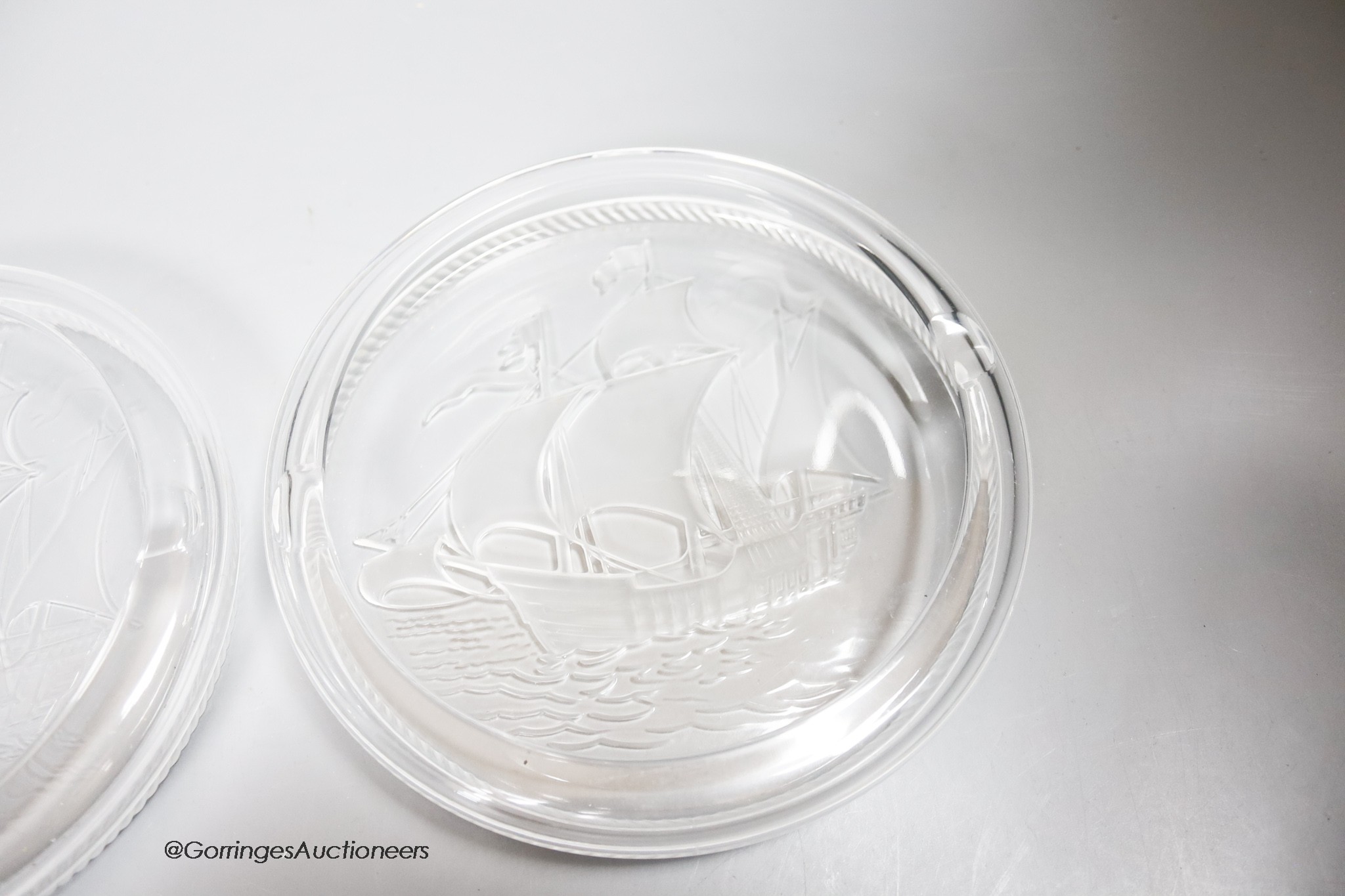 Two Lalique glass 'Santa Maria' ashtrays, moulded with clippers, signed, diameter 17cm